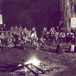 Bohemian Grove Lodge Guests Watching a Show While Laying Down Near the Camp Fire