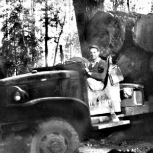 Man Driving an Overloaded Logging Truck Down a Narrow Dirt Road Near Austin Creek